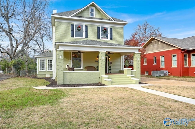 view of front facade featuring a front lawn, ceiling fan, cooling unit, and covered porch