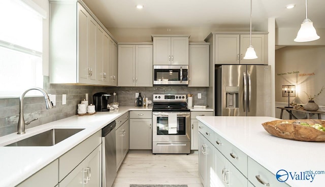 211 Bent Creek Ln, New Market, AL 35761 - kitchen featuring appliances with stainless steel finishes, a sink, light countertops, light wood-style floors, and backsplash
