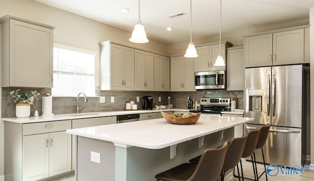 211 Bent Creek Ln, New Market, AL 35761 - kitchen featuring appliances with stainless steel finishes, a sink, decorative backsplash, a center island, and a kitchen breakfast bar