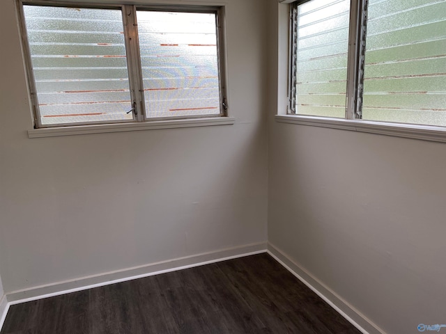 unfurnished room featuring plenty of natural light and dark hardwood / wood-style floors