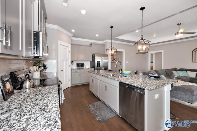 14614 Demarie Ln, Athens, AL 35613 - kitchen featuring stainless steel appliances, open floor plan, crown molding, light stone counters, and dark wood finished floors