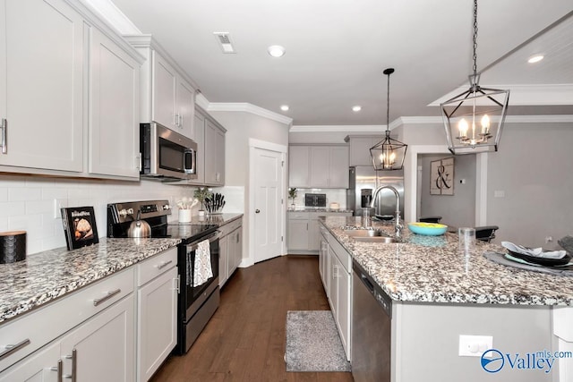 14614 Demarie Ln, Athens, AL 35613 - kitchen with appliances with stainless steel finishes, a kitchen island with sink, recessed lighting, ornamental molding, and tasteful backsplash