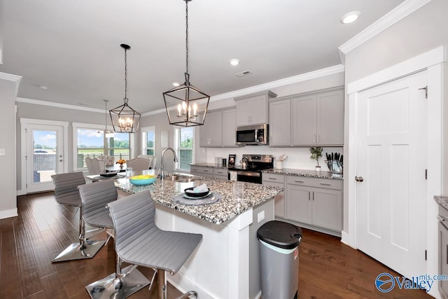 14614 Demarie Ln, Athens, AL 35613 - kitchen featuring appliances with stainless steel finishes, a kitchen bar, a chandelier, a center island with sink, and light stone counters