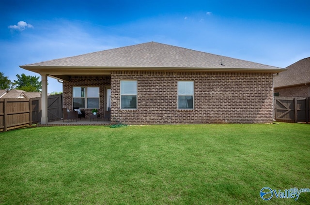 14614 Demarie Ln, Athens, AL 35613 - back of property featuring a fenced backyard, a gate, brick siding, and a patio area