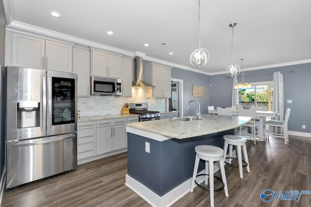 kitchen featuring wall chimney exhaust hood, a kitchen island with sink, stainless steel appliances, crown molding, and a sink