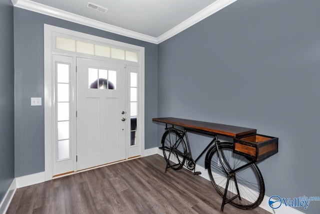 entrance foyer with ornamental molding, visible vents, baseboards, and wood finished floors