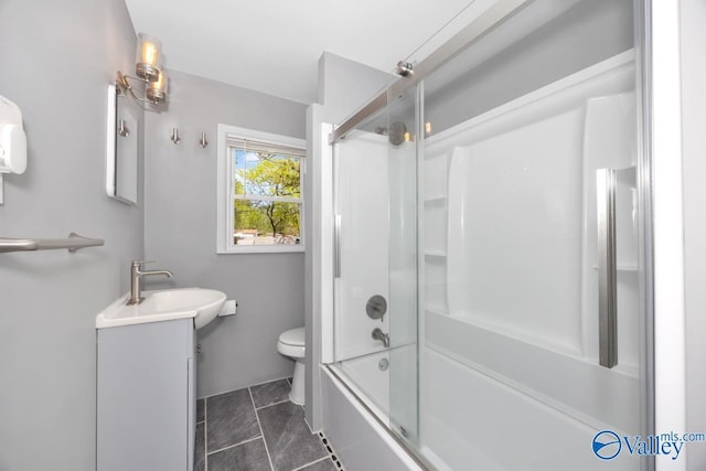 bathroom featuring combined bath / shower with glass door, vanity, and toilet