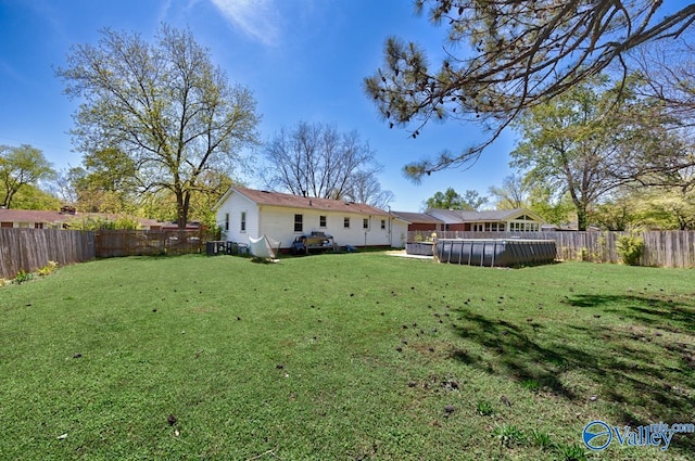 back of property with a fenced backyard and a yard