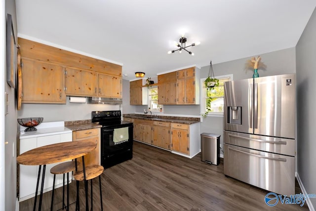 kitchen with dark countertops, black electric range, stainless steel refrigerator with ice dispenser, under cabinet range hood, and dark wood-type flooring
