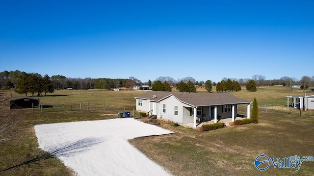 view of front facade with driveway, a front lawn, a porch, and a rural view