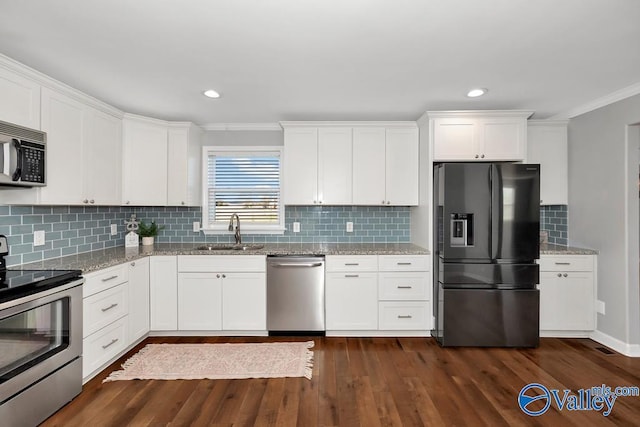 kitchen featuring light stone counters, appliances with stainless steel finishes, a sink, and white cabinetry