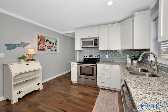 kitchen with light stone counters, dark wood finished floors, stainless steel appliances, backsplash, and a sink