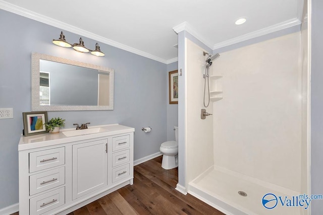 bathroom featuring ornamental molding, a stall shower, vanity, and wood finished floors