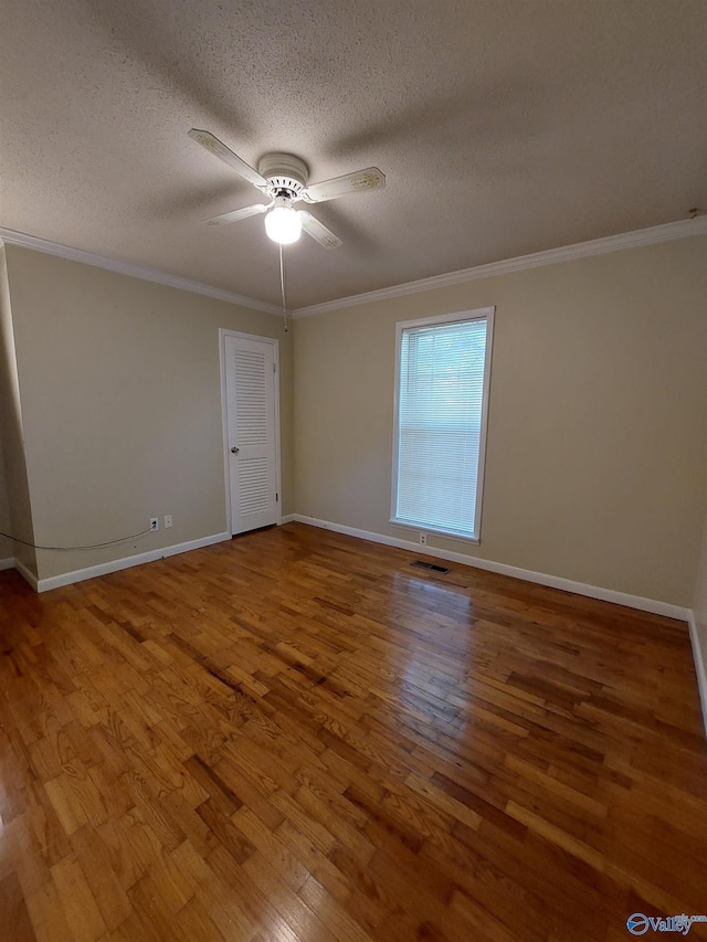 unfurnished room with wood-type flooring, ceiling fan, a textured ceiling, and crown molding