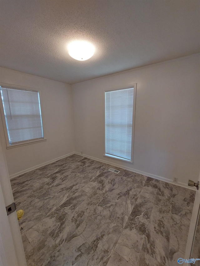 unfurnished room with a textured ceiling