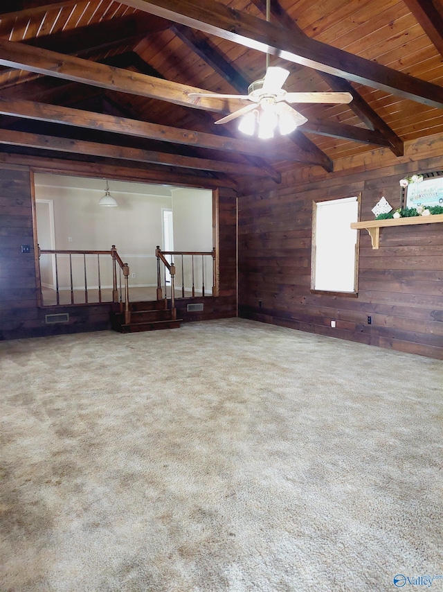 spare room with lofted ceiling with beams, carpet flooring, wood ceiling, and wooden walls