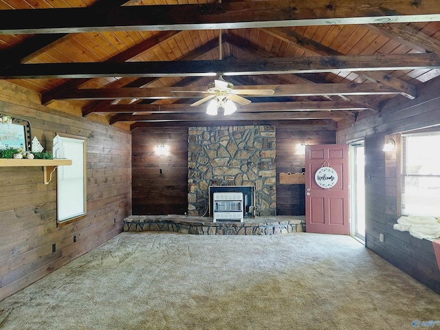 unfurnished living room with carpet floors, heating unit, and wood walls