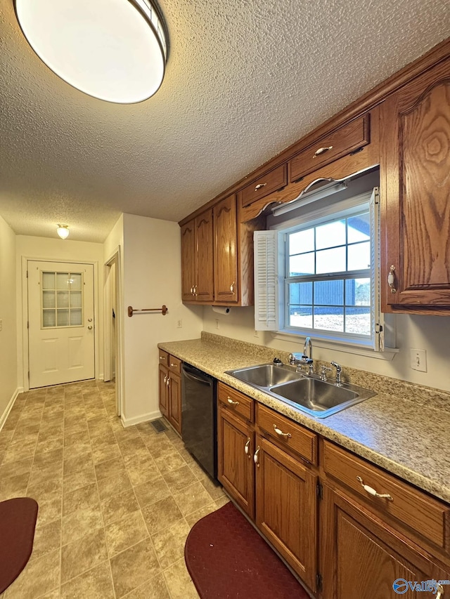 kitchen featuring dishwasher, sink, and a textured ceiling