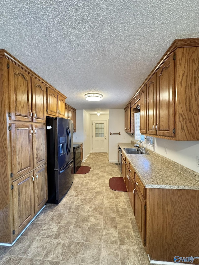 kitchen with a textured ceiling, sink, and black appliances