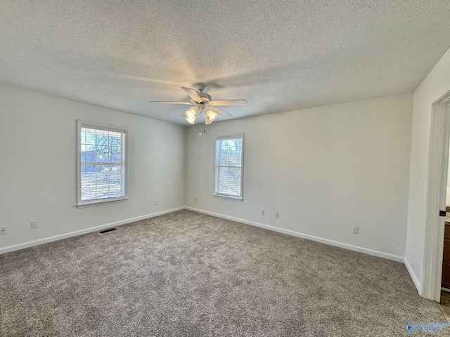 spare room with ceiling fan, plenty of natural light, and carpet flooring