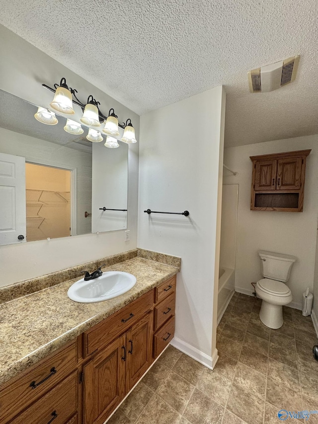 bathroom featuring toilet, vanity, and a textured ceiling