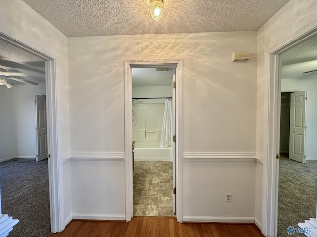 corridor with hardwood / wood-style flooring and a textured ceiling