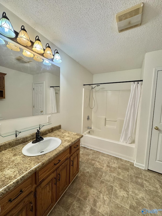 bathroom with a textured ceiling, shower / tub combo, and vanity