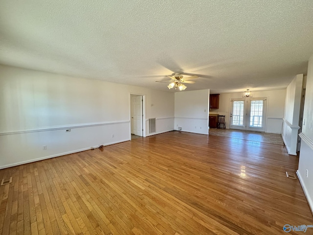 unfurnished living room with ceiling fan, wood-type flooring, and a textured ceiling