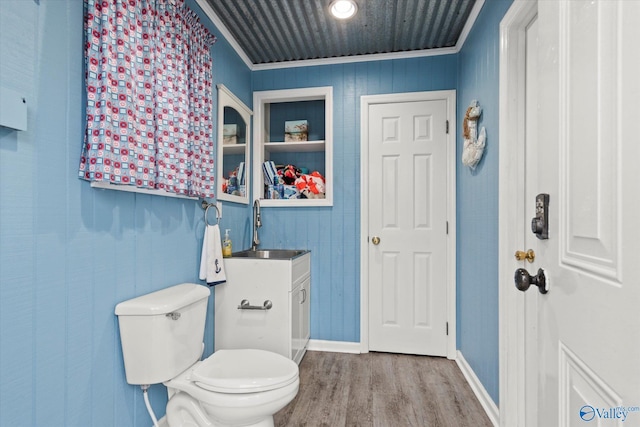 bathroom with hardwood / wood-style flooring, crown molding, vanity, and toilet