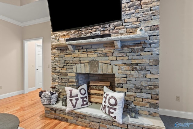 interior details featuring crown molding, a stone fireplace, and hardwood / wood-style floors