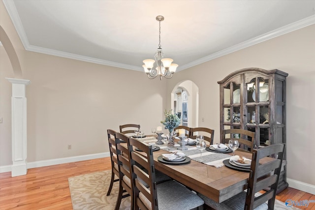 dining area with an inviting chandelier, ornamental molding, and hardwood / wood-style flooring