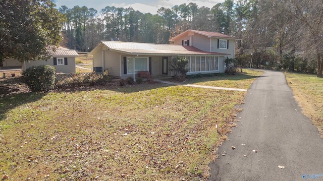 view of front facade with a sunroom and a front lawn