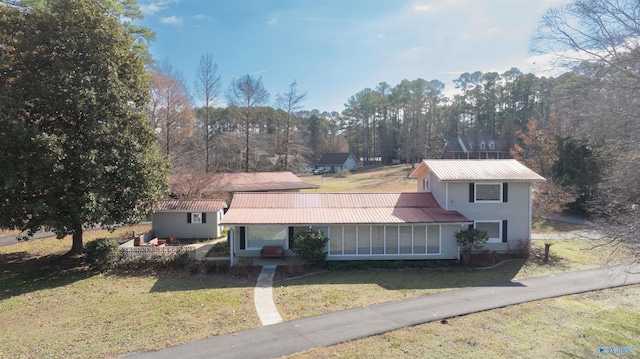 view of front of home featuring a front lawn and a sunroom