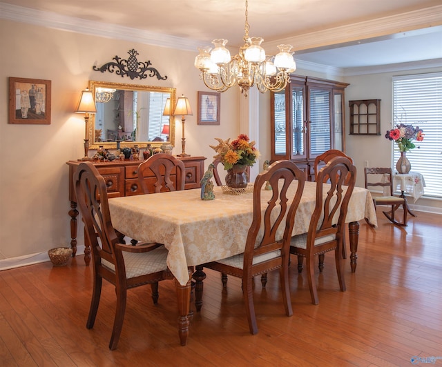 dining room with hardwood / wood-style floors, a notable chandelier, and ornamental molding