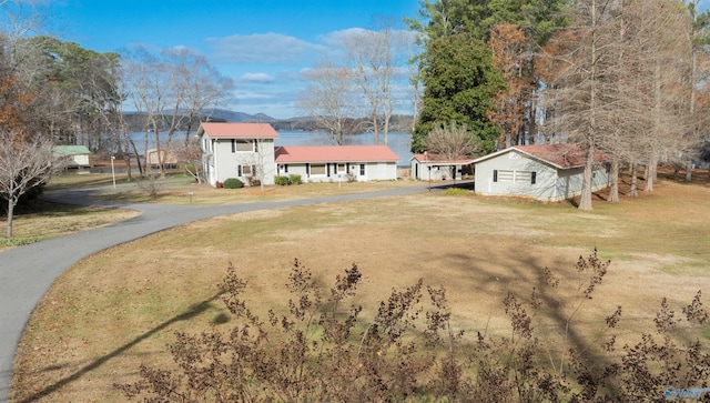 exterior space with a water view and a front lawn