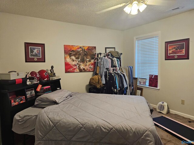 carpeted bedroom with ceiling fan and a textured ceiling