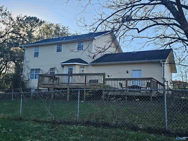 back of property featuring a wooden deck and a yard