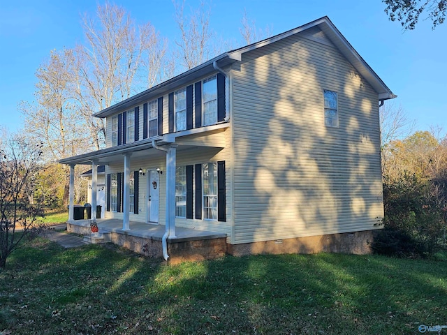 view of side of home with a lawn and a porch