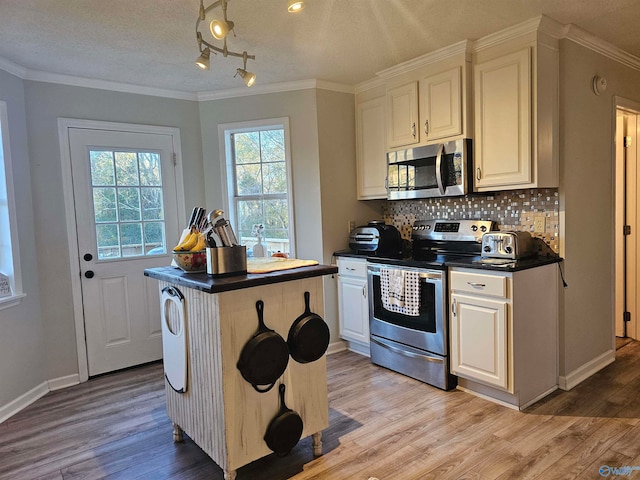 kitchen featuring a textured ceiling, stainless steel appliances, white cabinets, a center island, and light hardwood / wood-style floors