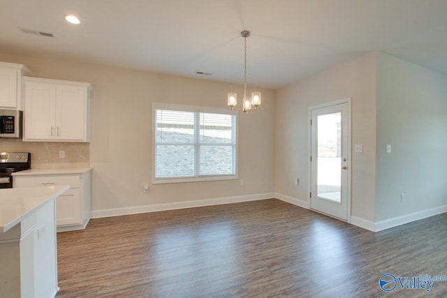 kitchen featuring dark wood-type flooring, a healthy amount of sunlight, white cabinets, and electric range