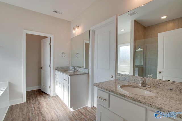 bathroom with wood-type flooring, an enclosed shower, and vanity