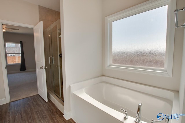 bathroom with independent shower and bath, hardwood / wood-style floors, and ceiling fan