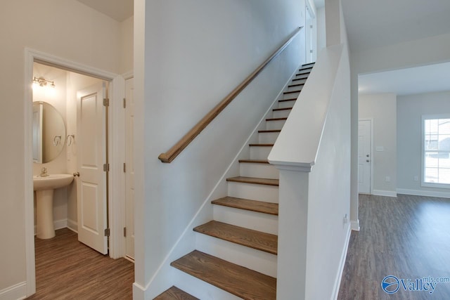 stairs featuring sink and wood-type flooring