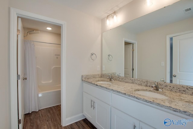 bathroom featuring shower / bathtub combination with curtain, hardwood / wood-style flooring, and vanity