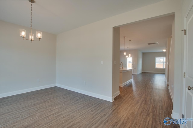 unfurnished room with dark hardwood / wood-style floors and a notable chandelier