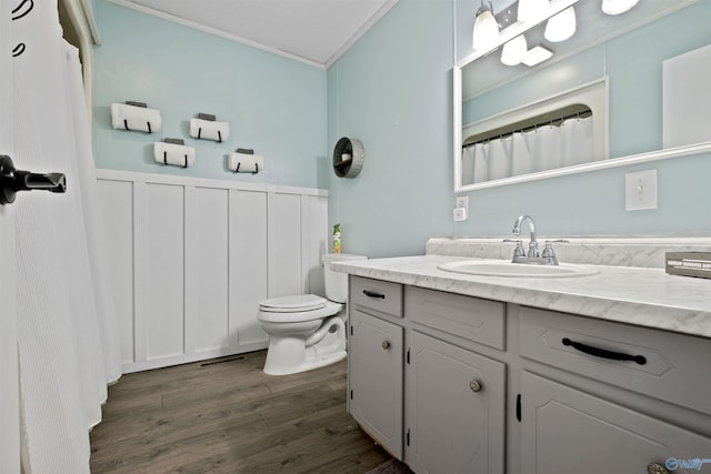 bathroom with vanity, hardwood / wood-style flooring, toilet, and crown molding