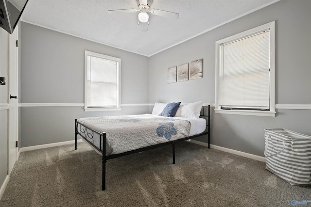 bedroom featuring ceiling fan, dark carpet, and a textured ceiling