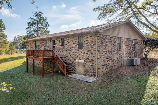 rear view of property featuring a yard and central AC