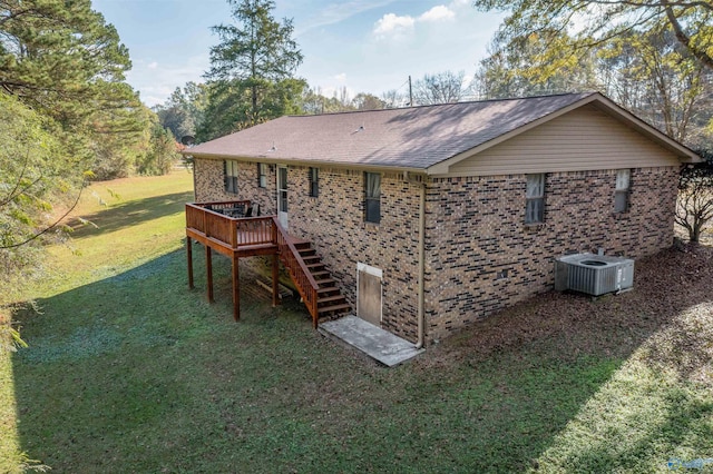 back of property with central AC unit, a deck, and a yard