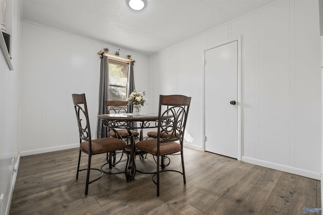 dining space with a textured ceiling and dark hardwood / wood-style flooring